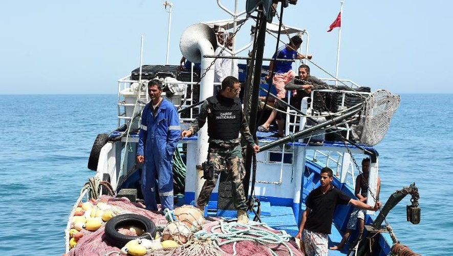 Un membre de la garde nationale tunisienne contrôle un chalutier dans les eaux de la Méditerranée bordant les côtes libyennes et tunisiennes, au large de Zarzis, dans le sud-est de la Tunisie le 5 mai 2015