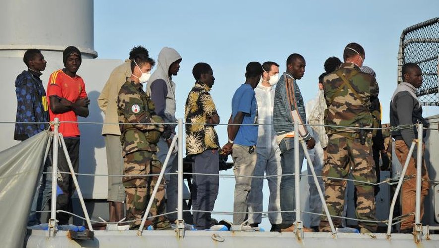 Des migrants secourus en mer attendent de débarquer du patrouilleur Commandant Birot dans le port italien de Crotone le 3 mai 2015