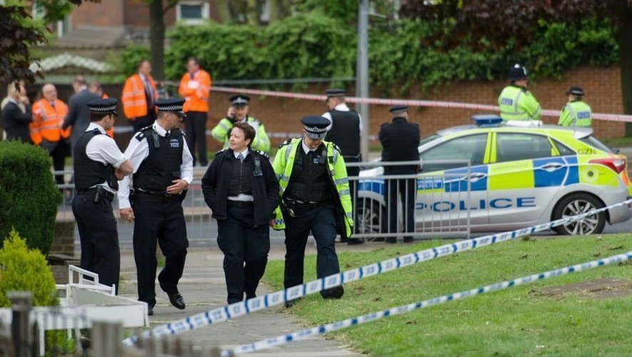 Des policiers près de l'endroit où un homme a été tué et deux suspects blessés dans l'est de Londres, le 22 mai 2013