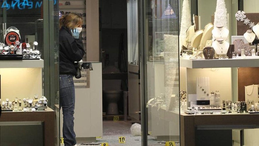 Une policière inspecte le 26 novembre 2011 une bijouterie de Cannes à la suite d'un braquage au cours duquel le propriétaire, Thierry Unik, a été tué d'une balle dans la tête