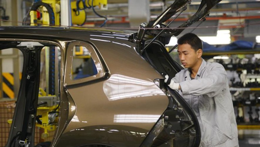Un ouvrier sur une chaîne de montage de l'usine Dongfeng Peugeot-Citroën Automobile  le 7 décembre 2014 à Wuhan en Chine