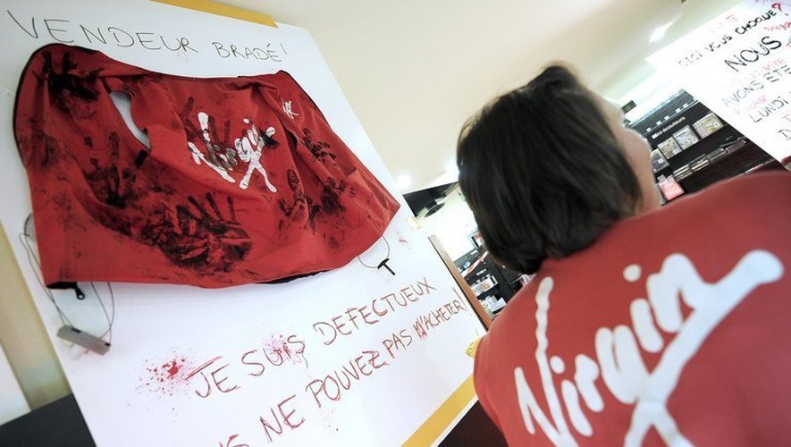 Des salariés de Virgin Megastore Strasbourg exposent, le 18 mai 2013, les produits cassés et abîmés après trois journées de destockage massif