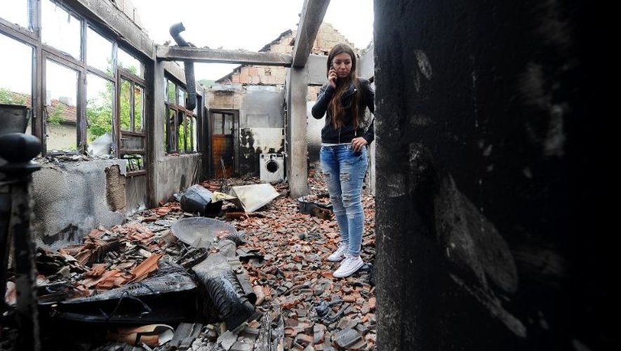 Une femme marche au milieu des débris de sa maison le 11 mai 2015 à Kumanovo, dans le nord de la Macédoine