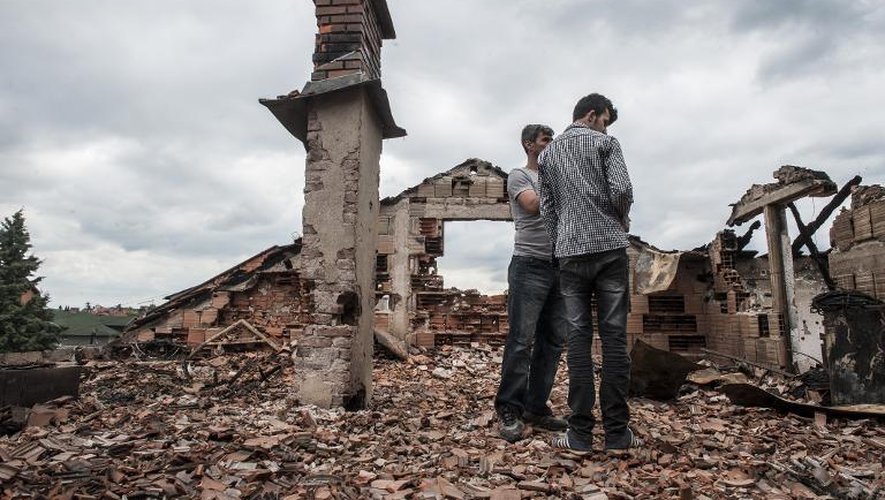 Des personnes se tiennent au milieu des débris de leur maison le 11 mai 2015 à Kumanovo, dans le nord de la Macédoine