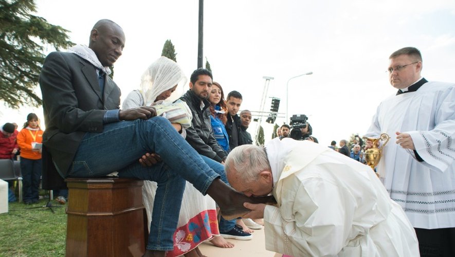 Photo fournie par les services de presse du  Vatican montrant le pape François accomplissant le rituel du lavement des pieds au centre d'accueil pour migrants à Castelnuovo di Porto, près de Rome, le 24 mars 2016