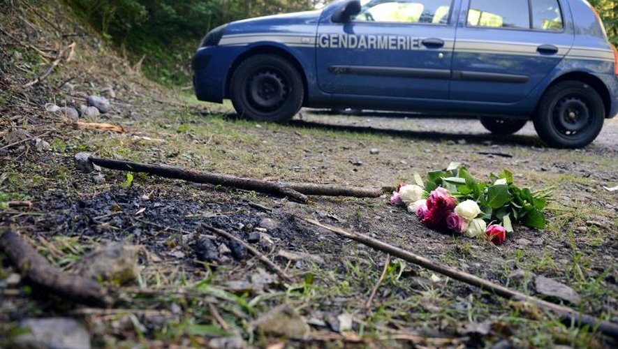 Un bouquet de rose près d'une voiture de gendarmerie sur les lieux du crime de Chevaline le 8 septembre 2012