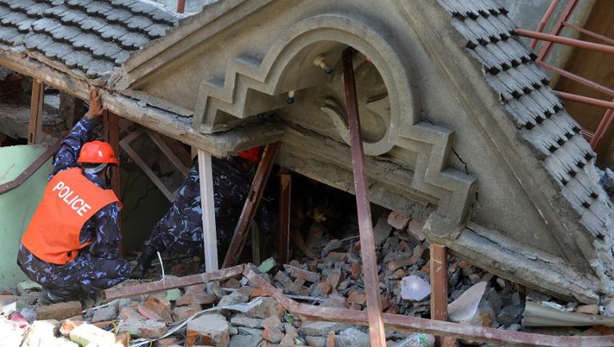 Un secouriste officiel recherche de possibles survivants dans les décombres d'une maison effondrée après un second séisme qui a touché le Népal, le 12 mai 2015 à Katmandou