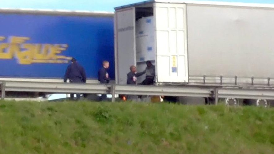 Image tirée d'une vidéo fournie par l'association Calais Migrant Sodidarity (CMS) montrant des policiers et un migrant sur le bord d'une route près de Calais dans le nord de la France, le 12 mai 2015