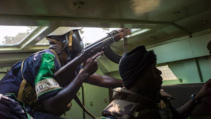 Des soldats de la Misca tirent sur des miliciens anti-balakas retranchés dans des quartiers proches de l'aéroport de Bangui, le 19 février 2014