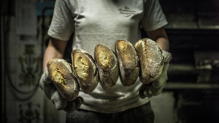 Une apprentie boulangère montre son pain tout juste sorti du four