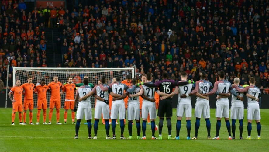 Les joueurs des Pays-Bas et de la France observent une minute de silence au début de leur match amical à Amsterdam, le 25 mars 2016