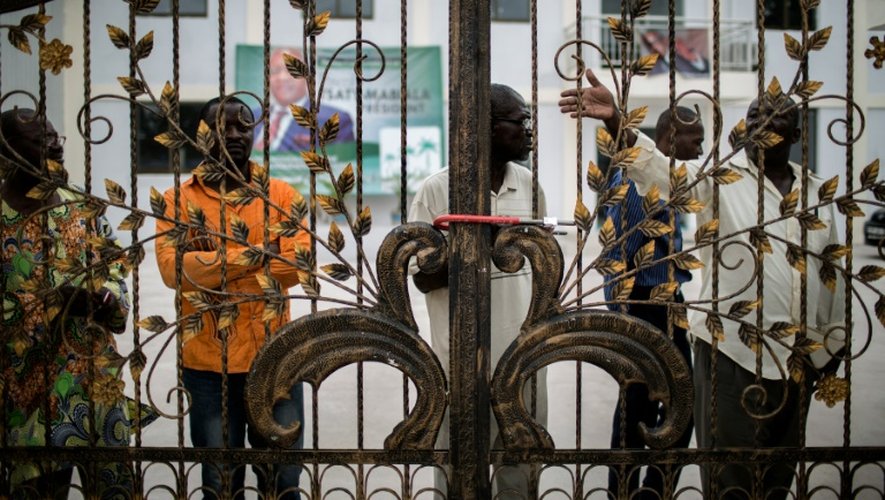 Des militants du parti d'opposition congolais UPADS derrière les grilles cadenassées du siège de leur parti à Brazzaville, le 25 mars 2016