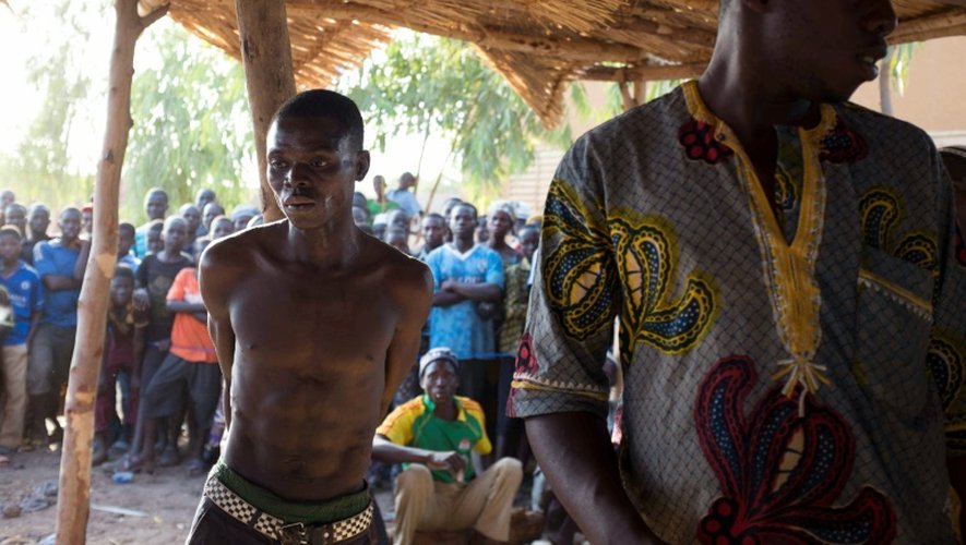 Un homme soupçonné de vol attaché à un poteau lors d'un "procès" expéditif conduit par des groupes d'autodéfense, le 19 mars 2016 à Kokologho près de Ouagadougou