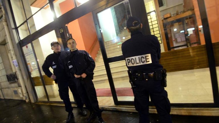 Des policiers devant l'entrée de l'immeuble où deux soeurs ont été poignardées, le 20 février 2014 à Paris