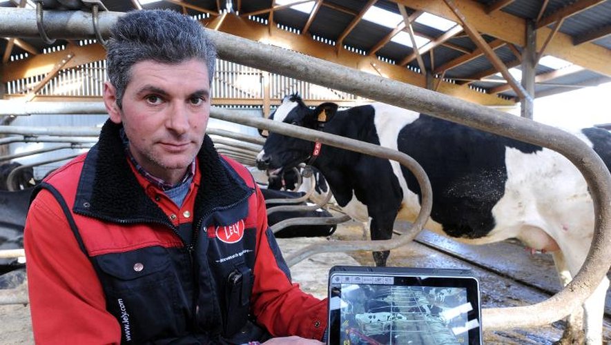 L'éleveur Jean-Pierre Dufeu et sa tablette pour surveiller l'étable, à Val d'Izé le 18 février 2014