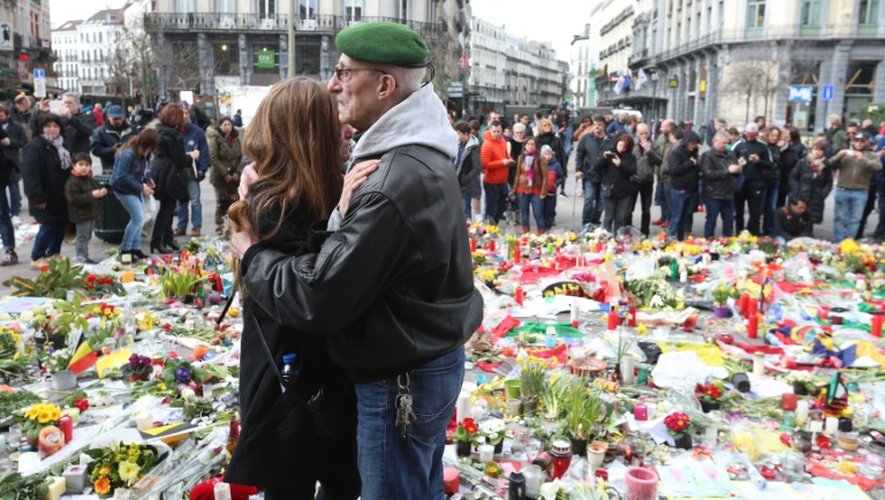 Des personnes se rassemblent en hommage aux victimes des attentats place de la Bourse à Bruxelles le 27 mars 2016