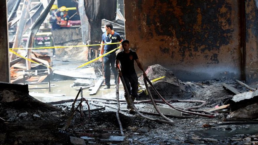 Pompiers au milieu des décombres après l'incendie d'une fabrique de chaussures, le 14 mai 2015 à Manille