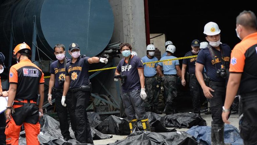 Les corps des victimes de l'incendie d'une usine de chaussures, alignés par les secours le 14 mai 2015 à Manille