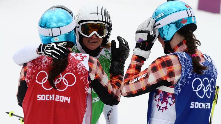 La Française Ophélie David (c) embrasse la médaillée d'or et d'argent olympique de skicross, les Canadiennes Marielle Thompson (d) et Kelsey Serwa (g), le 21 février 2014 à Rosa Khoutor