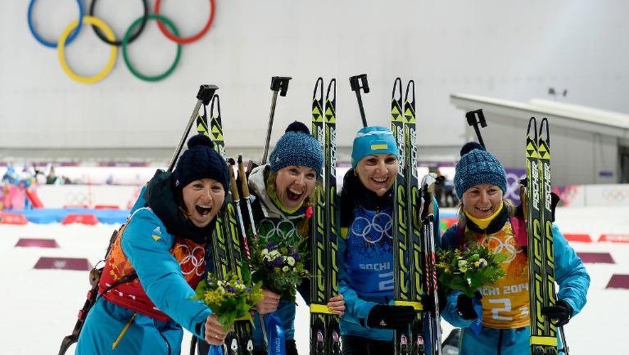 Les relayeuses ukrainiennes (de gauche à droite) Vita Semerenko, Juliya Dzhyma, Olena Pidhrushna et Valj Semerenko célèbrent leur victoire en biathlon sur le complexe Laura de Rosa Khoutor, le 21 février 2014