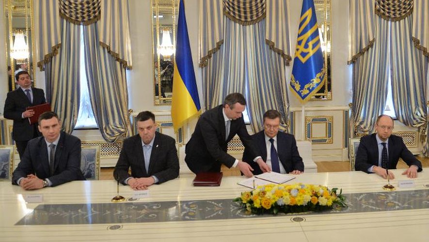 De g à d: les leaders de l'opposition Vitali Klitschko et Oleg Tiagnibok, le président ukrainien Viktor Ianoukovitch, et l'opposant Arseni Iatsenouk, signent un accord à Kiev, le 21 février 2014