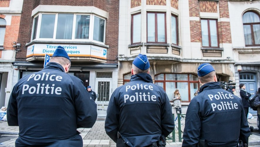 Trois officiers de police belges montent la garde dans la commune de Schaerbeek, dans la région de Bruxelles, le 25 mars 2016