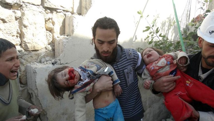 Des Syriens portent des enfants blessés après une attaque aérienne à Alep le 22 février 2014