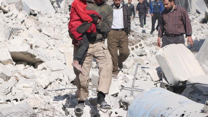 Un Syrien porte un enfant, après un raid aérien à Alep le 22 février 2014