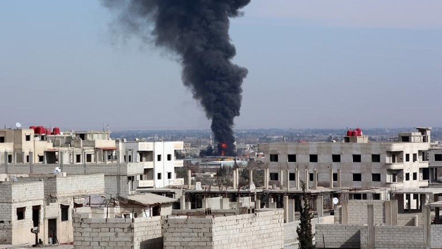 De la fumée s'élève d'un immeuble attaqué par un raid aérien à Damas le 22 février 2014