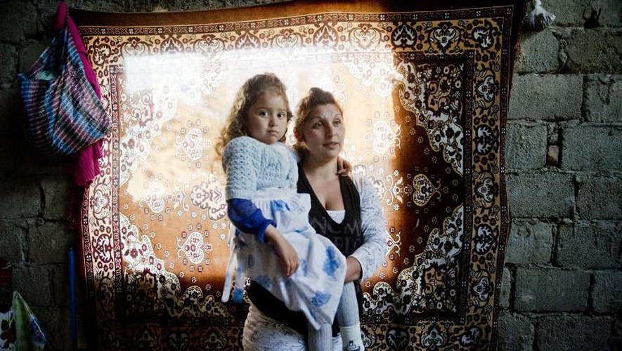 Dana tient dans ses bras Maria, sa fille de 4 ans, le 8 mai 2015 dans leur maison près de Craiova, en Roumanie