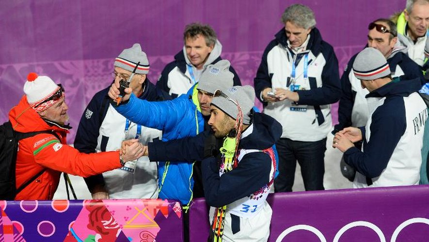 Avec 3 médailles dont deux en or, Martin Fourcade (C) félicité ici par ses compatriotes dans le complexe Laura de Rosa Khoutor le 13 février 2014, entre dans la cour des grands