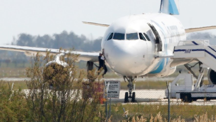 Un homme quitte l'Airbus A-320 de la compagnie EgyptAir qui stationne sur le tarmac de l'aéroport de Larnaca à Chypre le 29  mars 2016 après son détournement