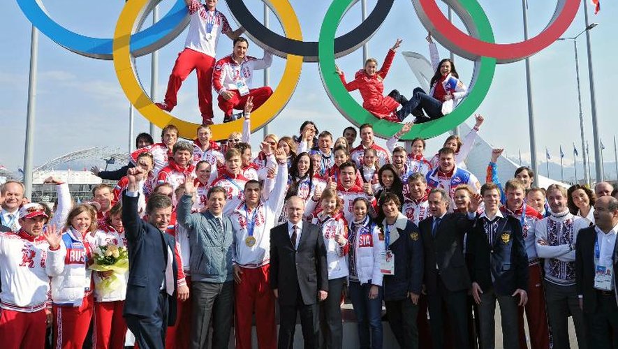 Le président Vladimir Poutine (C) pose avec les athlètes russes lors de la cérémonie de récompense après leurs exploits à Sotchi, le 24 février 2014