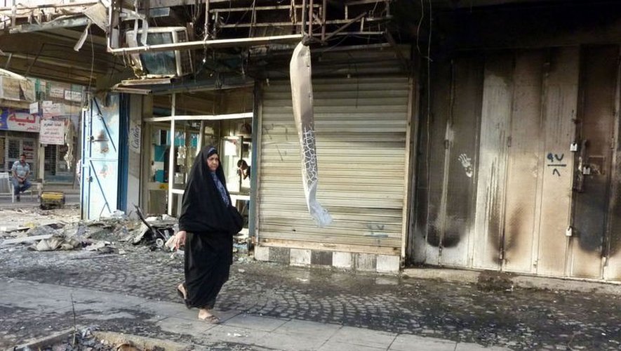 Une femme marche au milieu des décombres après les attenats de Bagdad, le 27 mai 2013