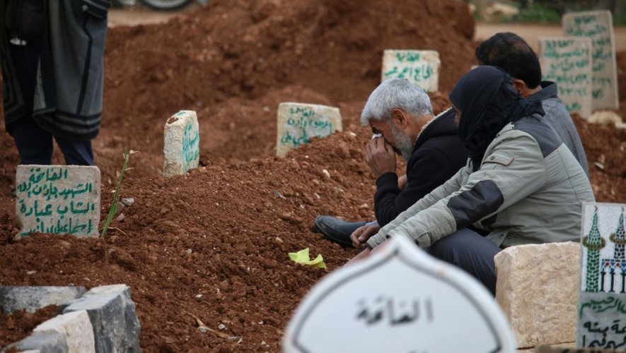 Des Syriens sur la tombe de leurs proches le 29 mars 2016 à Daraa
