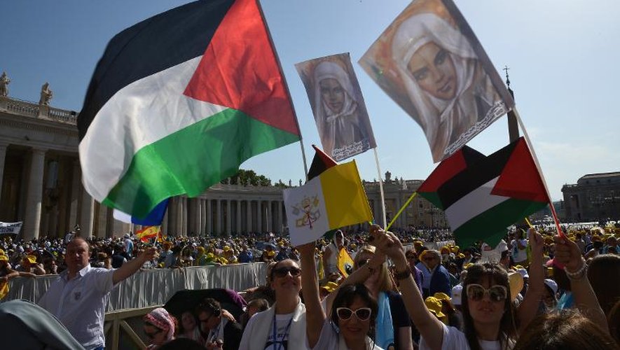 Des fidèles place Saint-Pierre avec des drapeaux palestiniens et les portraits de deux religieuses palestiniennes canonisées le 17 mai 2015 au Vatican