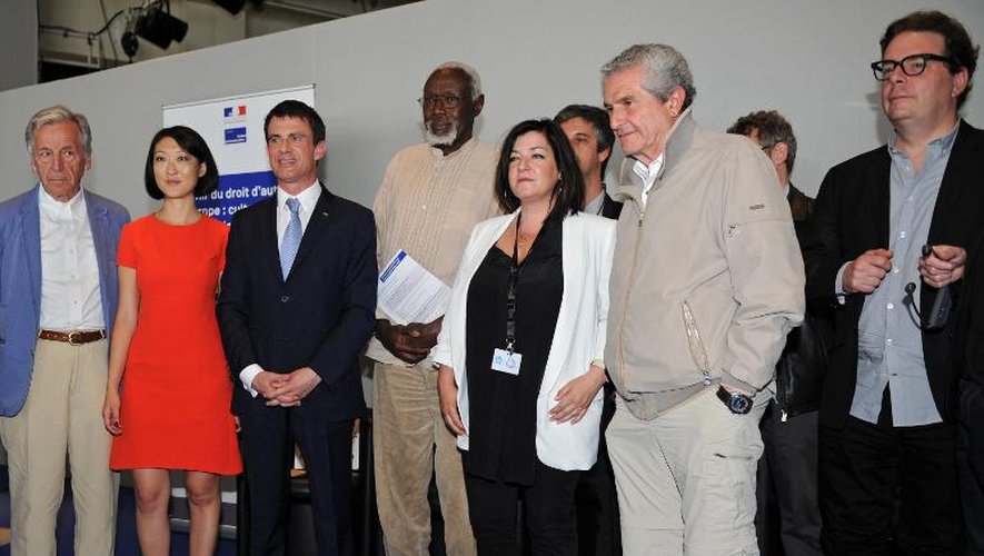 Manuel Valls et Fleur Pellerin posent avec le sculpteur Ousmane Sow, la réalisatrice Lynne Ramsay, le réalisateur Costa-Gavras, le réalisateur Claude Lelouch et l'écrivain Douglas Kennedy à l'issue d'une conférence sur les droits d'auteur en Europe, le 17 mai 2015 à Cannes
