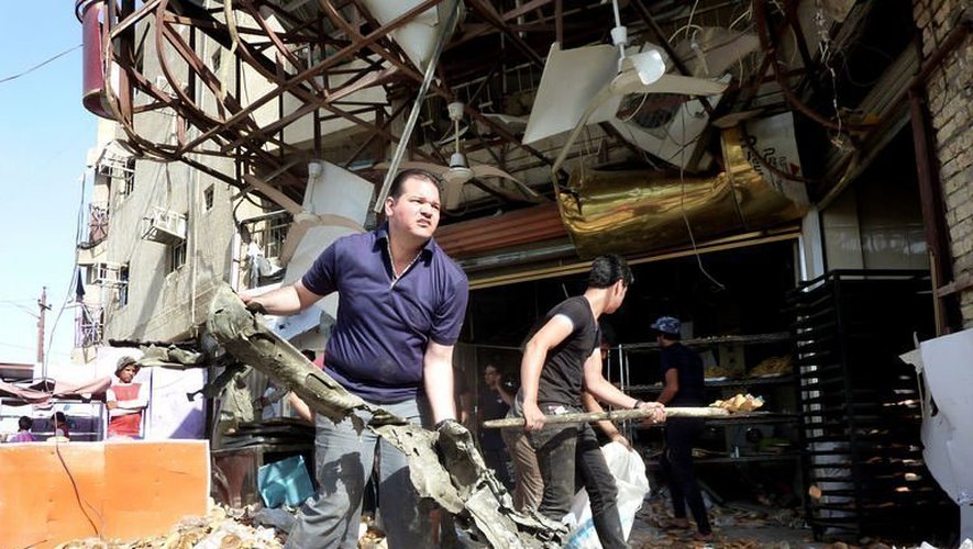 Des Irakiens nettoient les débris d'un attentat qui a fait au moins 6 morts, le 28 mai 2013 à Sadr City à Bagdad