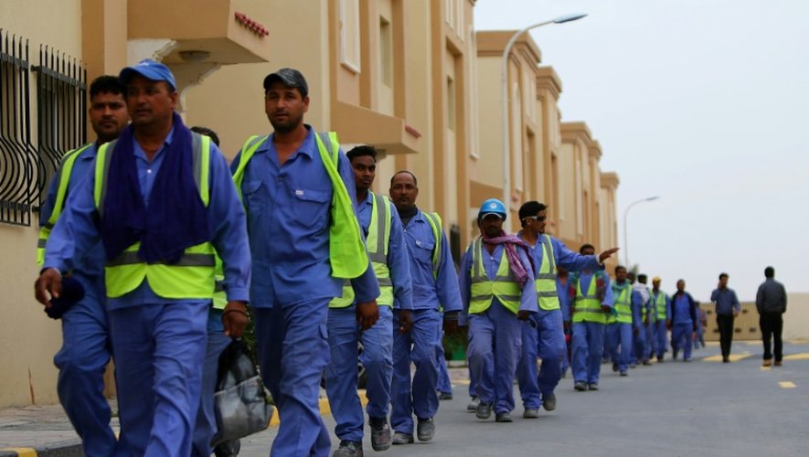 Des travailleurs immigrés de retour d'un site de construction du Mondial 2022 au Qatar, le 4 mai 2015 à Doha