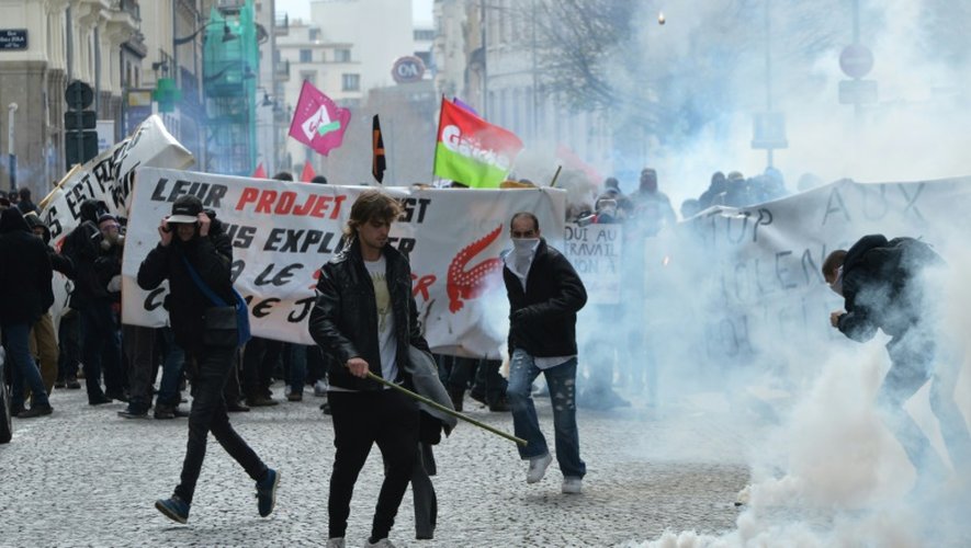 Des manifestants renvoient des grenades lacrymogènes vers les forces de police le 31 mars 2016 à Rennes
