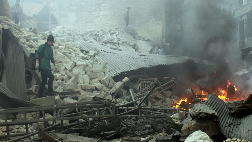 Des habitants d'Alep au milieu des décombres d'un bâtiment touché par une attaque aérienne de l'armée syrienne, le 26 février 2014