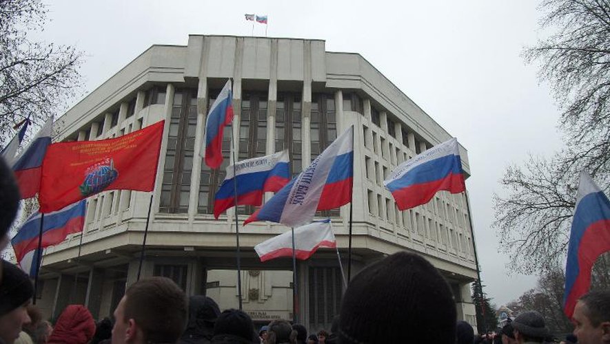 Des pro-Russes manifestent devant le Parlement de Crimée sur lequel flotte le drapeau russe, le 27 février 2014 à Simféropol