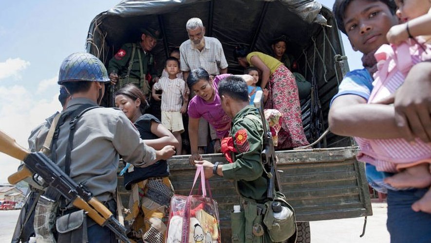 Des soldats aident des familles musulmanes qui se réfugient dans un monastère le 30 mai 2013 à Lashio, en Birmanie