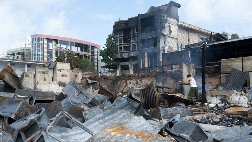 Un homme commence à déblayer un marché brûlé lors de violences religieuses à Lashio, le 30 mai 2013