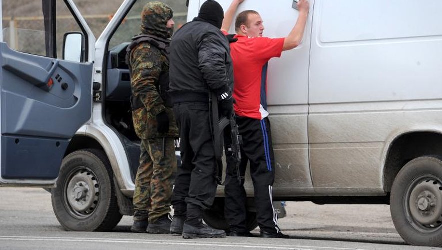 Un homme contrôlé par des hommes masqués et armés le 28 février 2014 à un point de passage à Armiansk