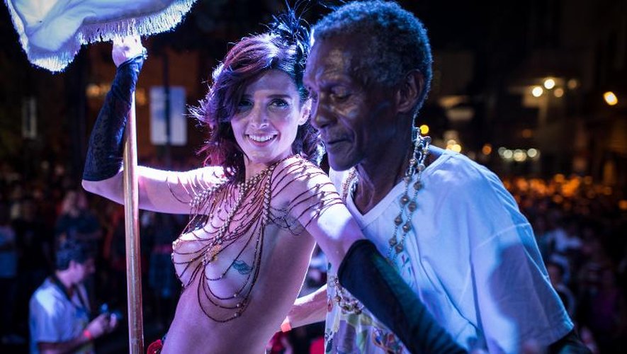 La cinéaste brésilienne Ana Paulo Goncalves et un danseur dans les rues de Rio de Janeiro le 27 février 2014, la veille du carnaval