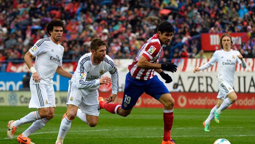 L'attaquant de l'Atlético, Diego Costa (c), devant Sergio Ramos et Pepe (g), du Real Madrid, le 2 mars 2014 au Vicente-Calderon de Madrid