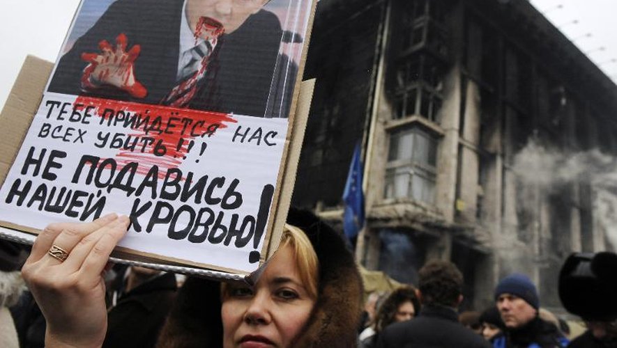 Une manifestante brandit une photo de Poutine présenté comme le diable le 2 mars 2014 à Kiev