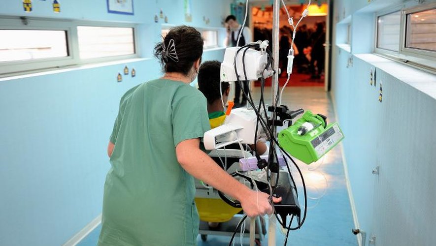 Une infirmière avec un jeune malade dans le couloir d'un établissement hospitalier