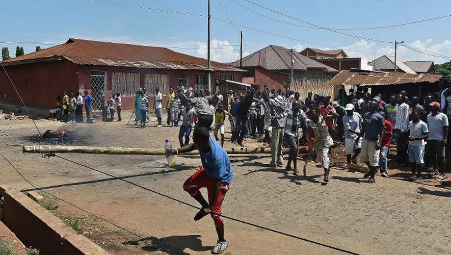 Des opposants à un troisième mandat du président Nkurunziza font tomber un poteau téléphonique pour dresser une barricade dans le quartier de Ngaragara, le 21 mai 2015 à Bujumbura